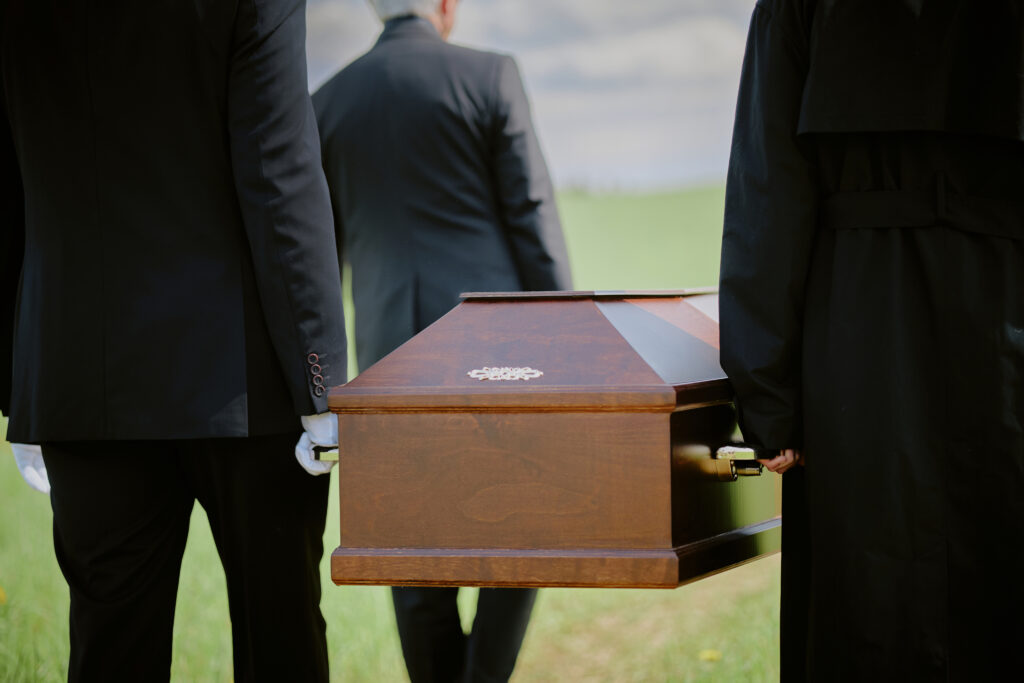 Personnes portant un cercueil en bois, cérémonie funéraire.